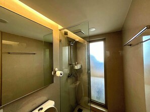 Een moderne badkamer met een douchecabine van glas, een toilet en een grote spiegel.