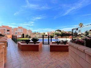 A rooftop terrace with tiled flooring, planters, and a view of surrounding buildings. - Coastal Family Apartment in Roquetas de Mar (Roquetas de Mar)