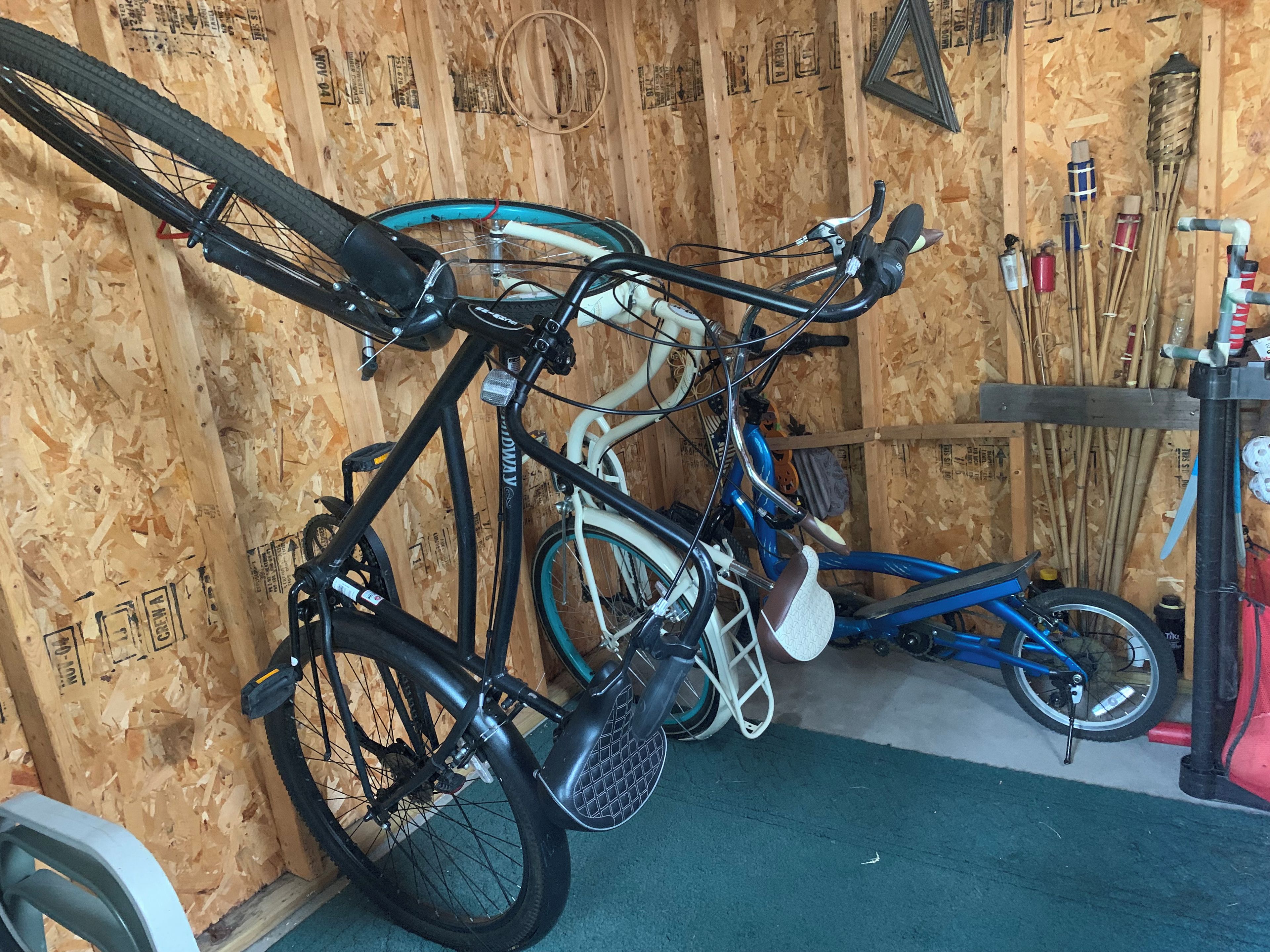 A room with wooden walls, a bicycle rack, and a table with various items.