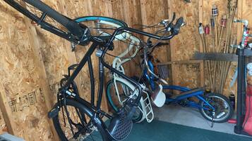 A room with wooden walls, a bicycle rack, and a table with various items.
