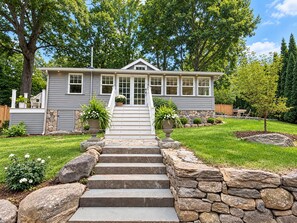 A two-story house with a stone staircase leading to a front door. - The Flirt - Restored 1927 Cottage at Lake Waramaug (New Preston)