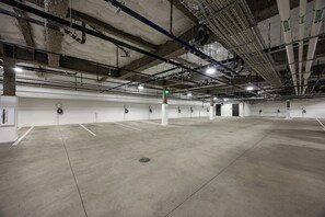 A spacious indoor parking area with concrete floors, white walls, and multiple parking spaces. - AMB402 | Brand New Luxury Complex | Pool | Hot Tub | A/C | Winter Shuttle (Steamboat Springs)