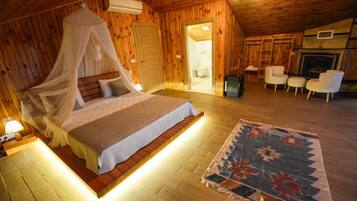 Une chambre confortable, aménagée dans un chalet en bois, avec un lit, un tapis et une cheminée.
