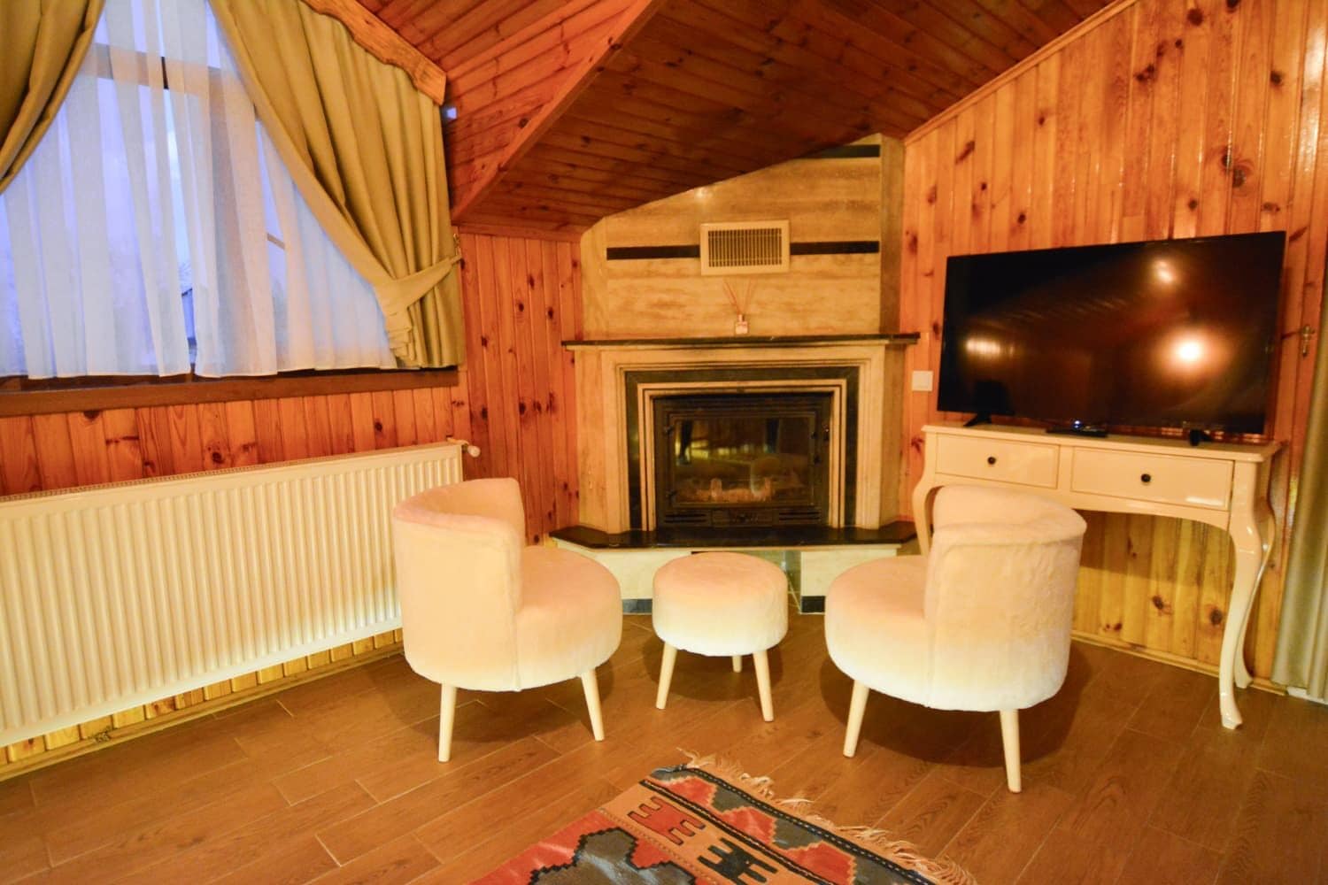 Una habitación acogedora con chimenea, televisión y dos sillones.