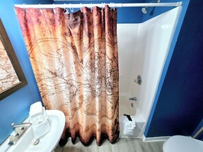 A bathroom with a shower curtain featuring a map design, a white sink, and a toilet. - 1 Block to Beach | 3BR Gulf Shores Home, Sleeps 8 (Gulf Shores)