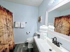 A bathroom with a toilet, sink, and mirror. - 1 Block to Beach | 3BR Gulf Shores Home, Sleeps 8 (Gulf Shores)