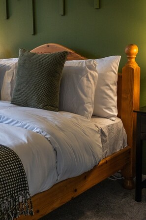 A wooden bed with white bedding and a green wall. - Modern home, ideal for long stays Free Parking (West Sussex)