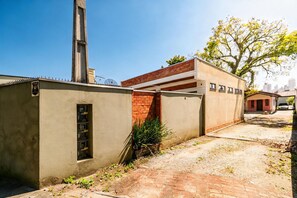 Un edifici amb mur de maó, tanca metàl·lica i cel serè.
