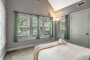 A bedroom with a bed, a window with blinds, a door, and a ceiling vent. - Minutes to SoCo - Sleeps 10 w Studio, Near DT (Austin)
