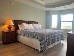 A bedroom with a bed, nightstand, lamp, and a window with blinds. - Monterey Bay - Three Bedroom Apartment, Sleeps 8 (Village of Four Seasons)