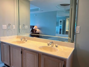 Ein Badezimmer mit zwei Waschbecken, einem großen Spiegel und Holzschränken.
