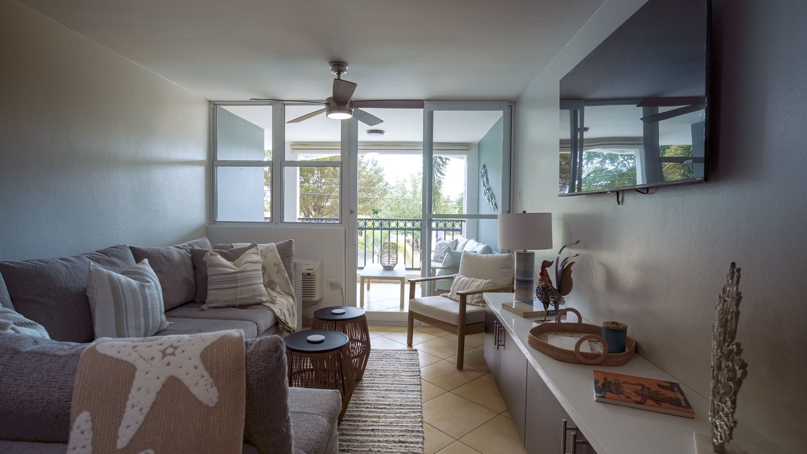 A living room with a sofa, a small table, a chair, a lamp, and a decorative rooster.