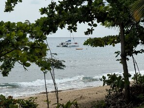 A beach with a boat named 'KATARINA' anchored in the water, surrounded by foliage. - Little Corner of Paradise Sleeps 6, 2 Bath, 2 Room (Rincon)