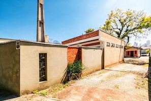 A building with a brick facade, a small window with a metal frame, and a satellite dish on the roof. - Casa c Churrasqueira e Wi-fi Perto do Roodertown (Balneário Camboriú)