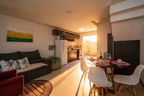 A compact living space with a kitchenette, a dining area, and a sofa. - Casa c Churrasqueira e Wi-fi Perto do Roodertown (Balneário Camboriú)