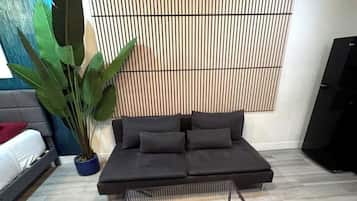 A modern living room with a sectional sofa, a glass coffee table, and a large potted plant.