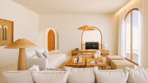 A modern living room with a sofa, a coffee table, and a television. There is a large window with curtains, a lamp, and a framed picture on the wall. - Ando Living - Comporta Villas - Villa 2 (Carvalhal)