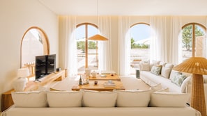 Un salón amplio con un sofá grande, un televisor y una zona de comedor.