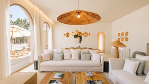 Ein modernes Wohnzimmer mit einer großen Couch, einem Couchtisch und einem Essbereich mit Tisch für zwei Personen.