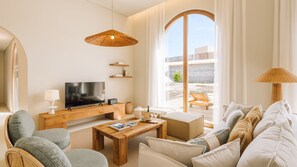 A modern living room with a television, wooden coffee table, and comfortable seating. - Ando Living - Comporta Villas - Villa 9 (Carvalhal)