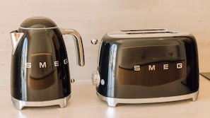 Two black Smeg appliances, a kettle and a toaster, on a countertop. - Ando Living - Comporta Villas - Villa 9 (Carvalhal)