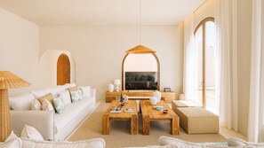 Ein modernes Wohnzimmer mit einem weißen Sofa, einem Holztisch und einem Fernseher.