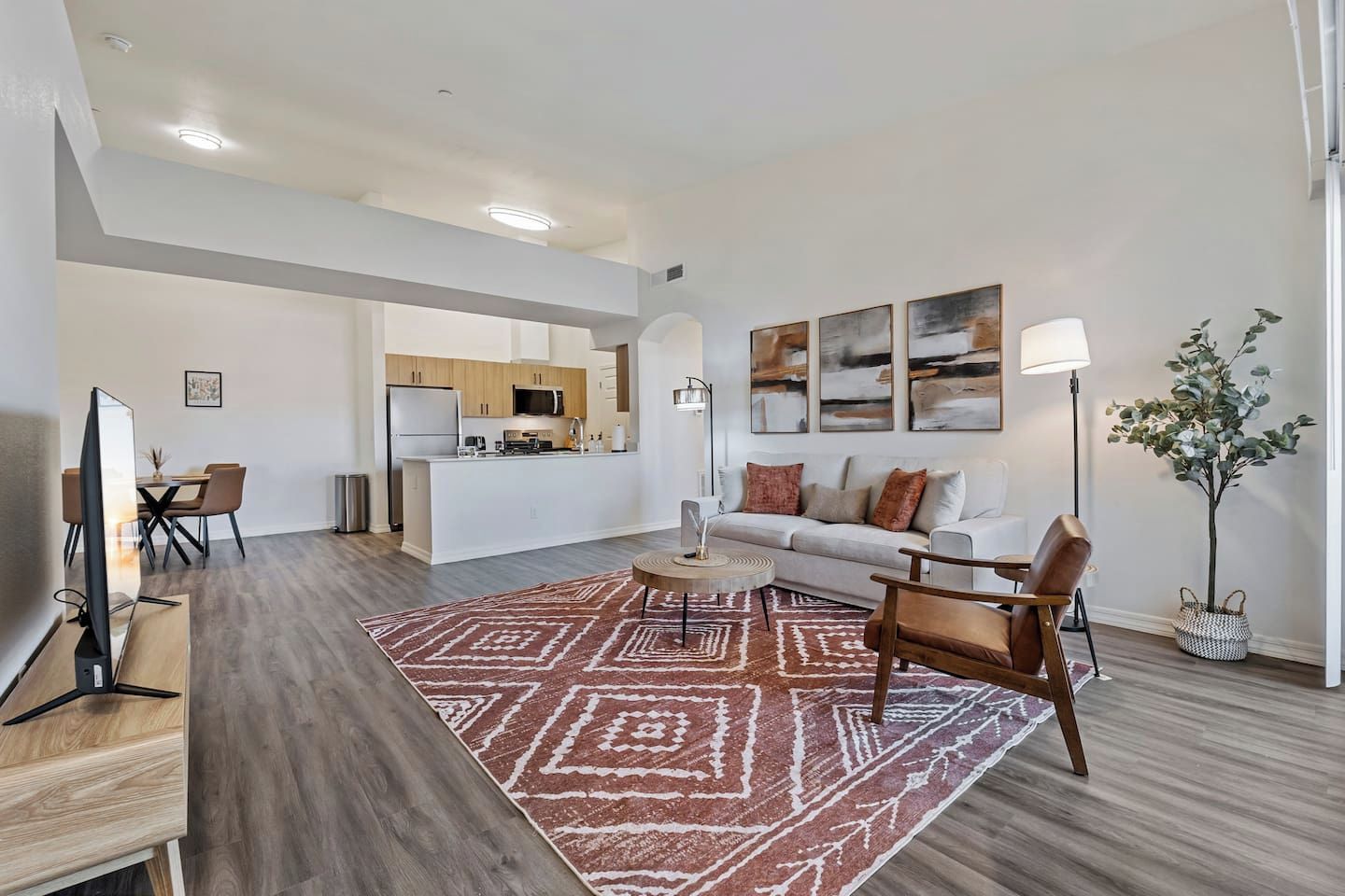 Un salon moderne avec un canapé, une table basse et un coin repas avec des chaises.