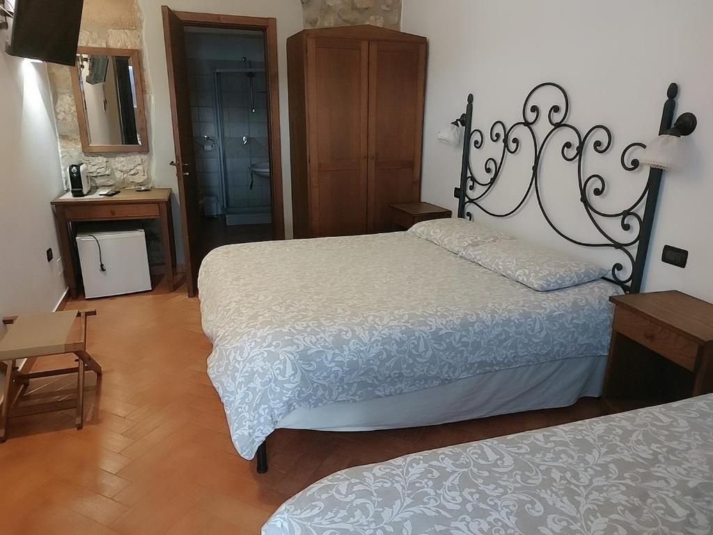 Ein Schlafzimmer mit einem Bett, einem Holzschrank, einem Schreibtisch mit Stuhl und einem Badezimmer mit Dusche.