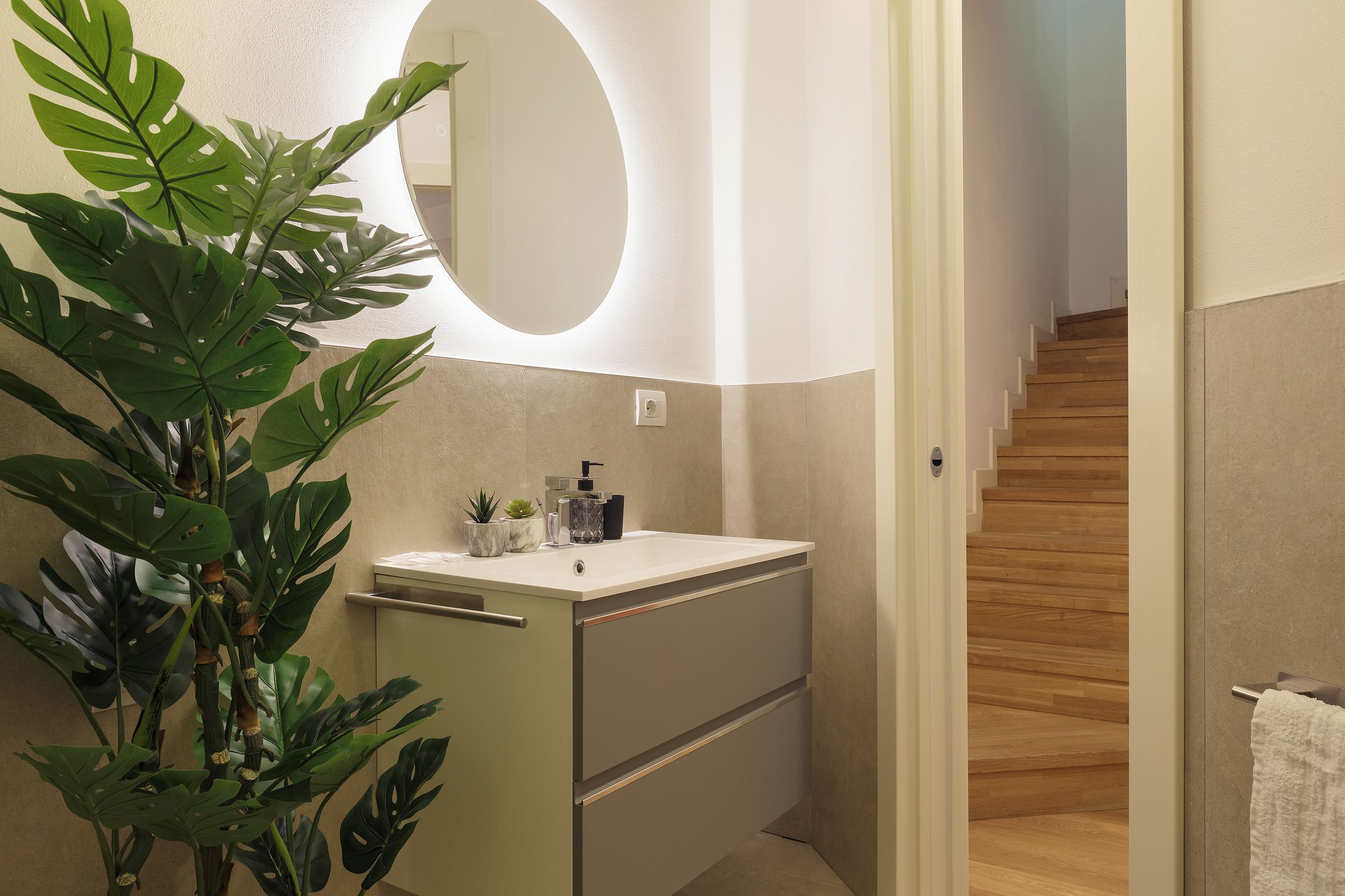 Ein Badezimmer mit Waschbecken, Spiegel und Topfpflanzen.