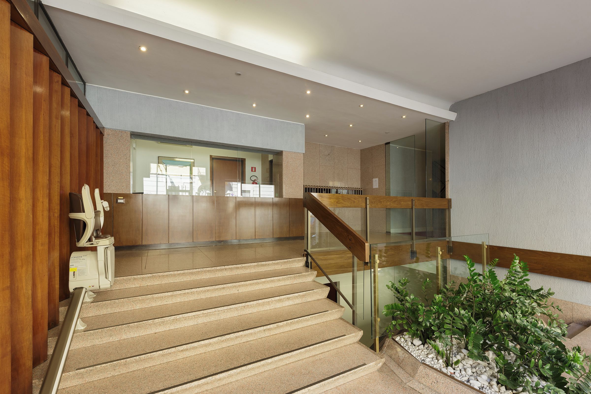 Ein modernes Interieur mit Treppe, Holzvertäfelung und einer Rezeption.