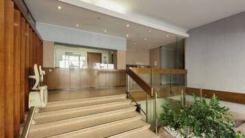 Ein modernes Interieur mit Treppe, Holzvertäfelung und einer Rezeption.