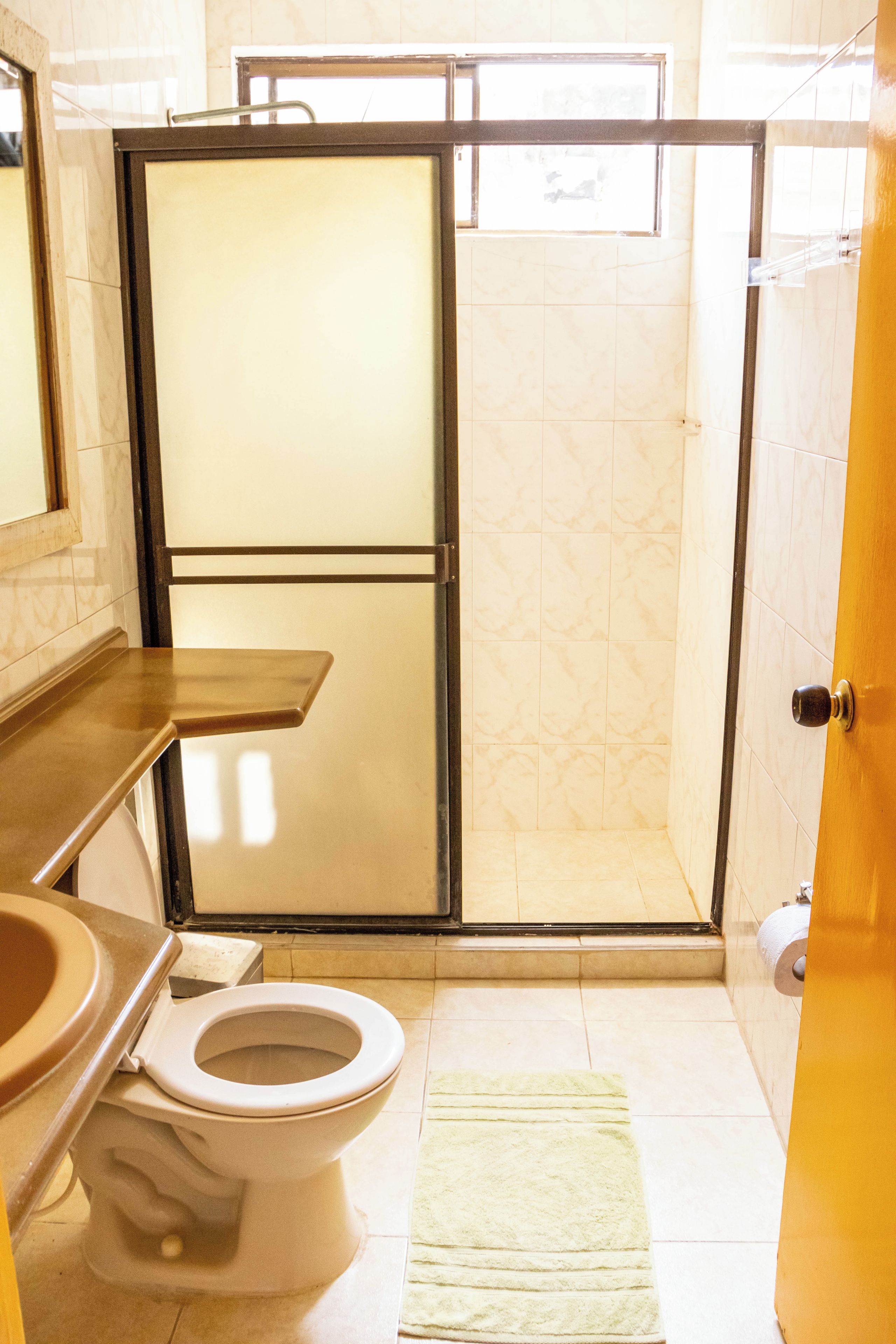 A bathroom with a toilet, sink, and shower area.