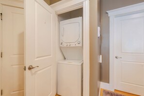 A laundry room with a washer and dryer, a door, and a wall-mounted thermostat. - Cambridge Cozy Home ,3bedroom/2bath ,Sleeps 8 (Cambridge)