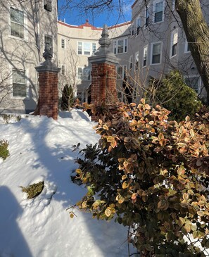 A snow-covered pathway leading to a building with a brick chimney and a large window. - Cambridge Cozy Home ,3bedroom/2bath ,Sleeps 8 (Cambridge)
