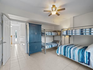 A dormitory room with bunk beds, a wardrobe, and a ceiling fan. - The Bent Palm (Kure Beach)