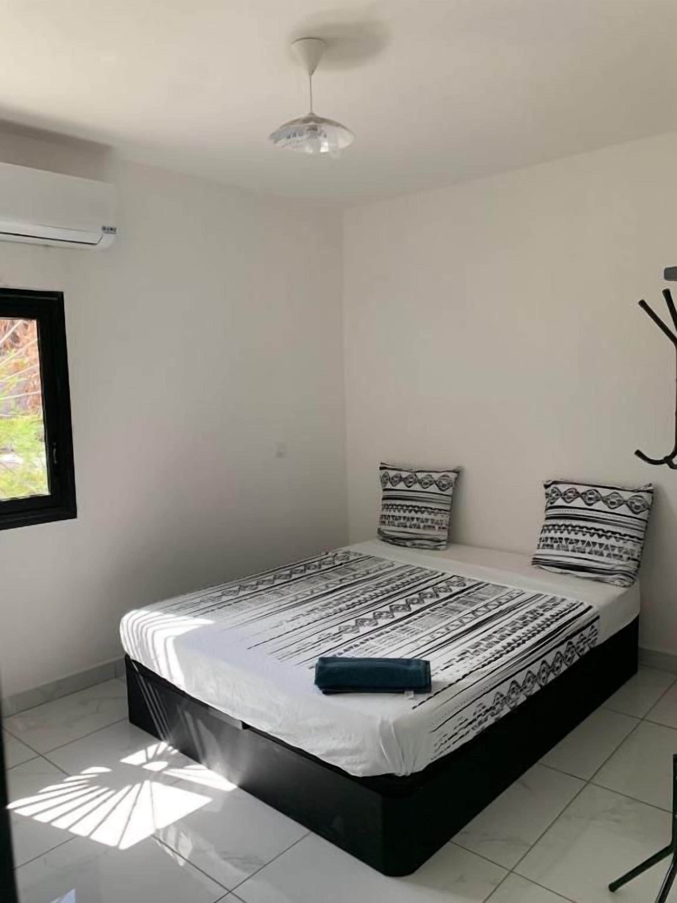 A room with a bed, a window, and a ceiling fan.