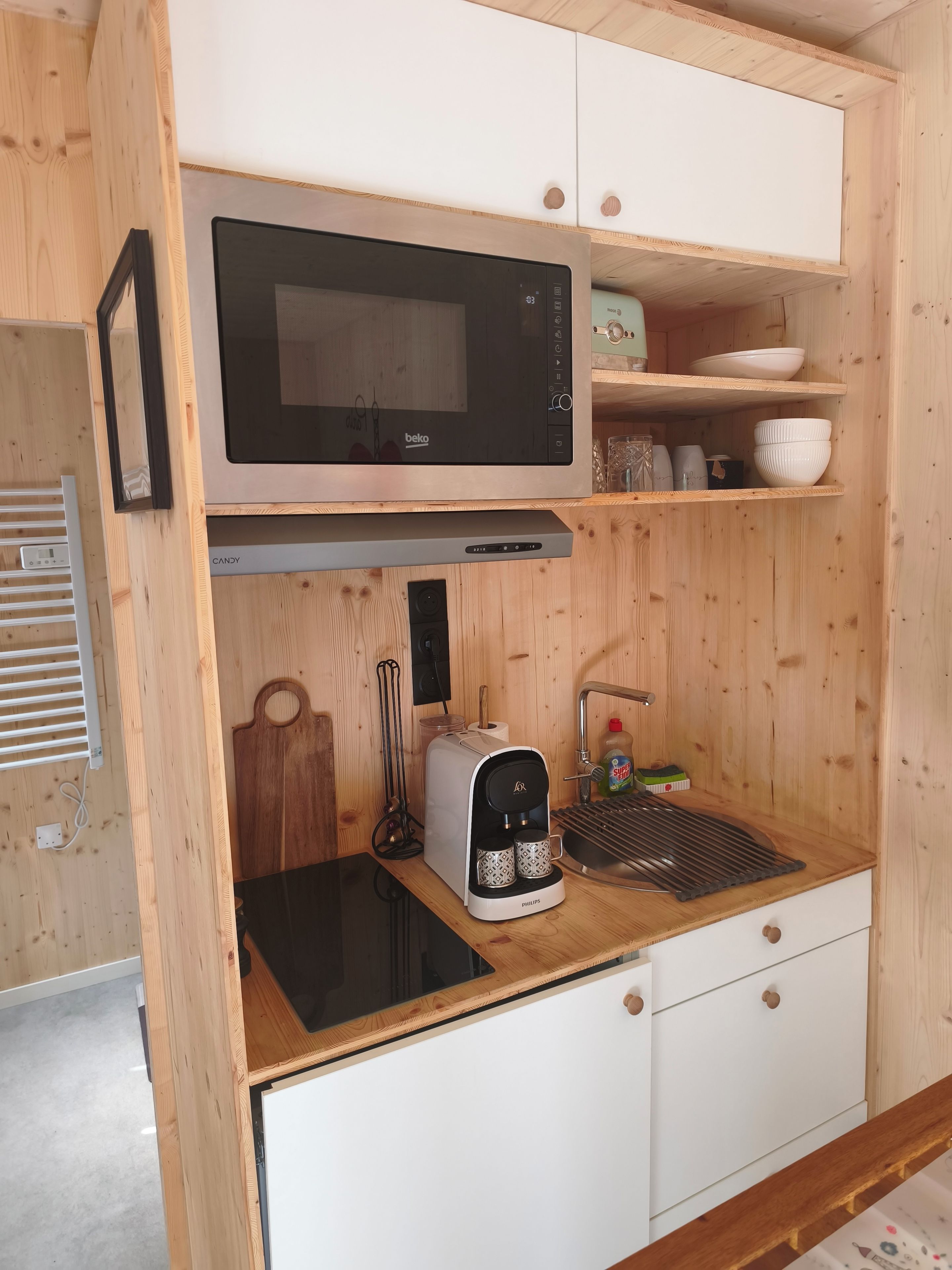 Una kitchenette compacta con microondas, tostadora y cafetera.