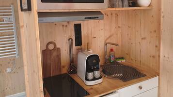 Una kitchenette compacta con microondas, tostadora y cafetera.