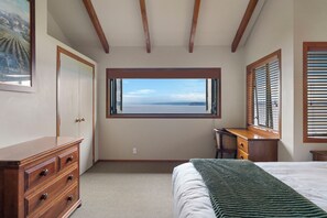 A bedroom with a large window, a bed, a dresser, and a desk. - Fern View - Pukawa Bay Holiday Home (Turangi)