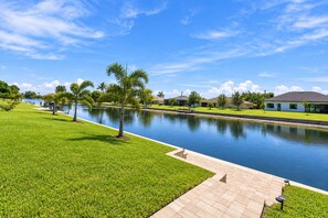 Área residencial com piscina, gramados verdes e casas.