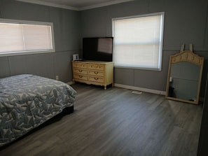A bedroom with a bed, dresser, TV, and a mirror. - Beautiful 3-bedroom mobile home with AC in Port Orange (Port Orange)