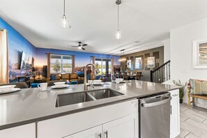 A modern kitchen with a central island, stainless steel appliances, and a dining area with a view. - Sleeps 24 - Pool-Game Room-Disney-Cinema Room (Davenport)