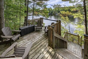 A wooden deck with Adirondack chairs and a table overlooking a lake. - Classic Cottage Living on Muldrew Lake - 4 bedroom, 3 bath (Parry Sound Mid-Shore (Bala))