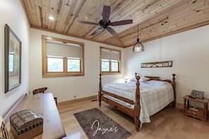 A bedroom with a wooden ceiling, a bed, a desk, and a chair. - Classic Cottage Living on Muldrew Lake - 4 bedroom, 3 bath (Parry Sound Mid-Shore (Bala))