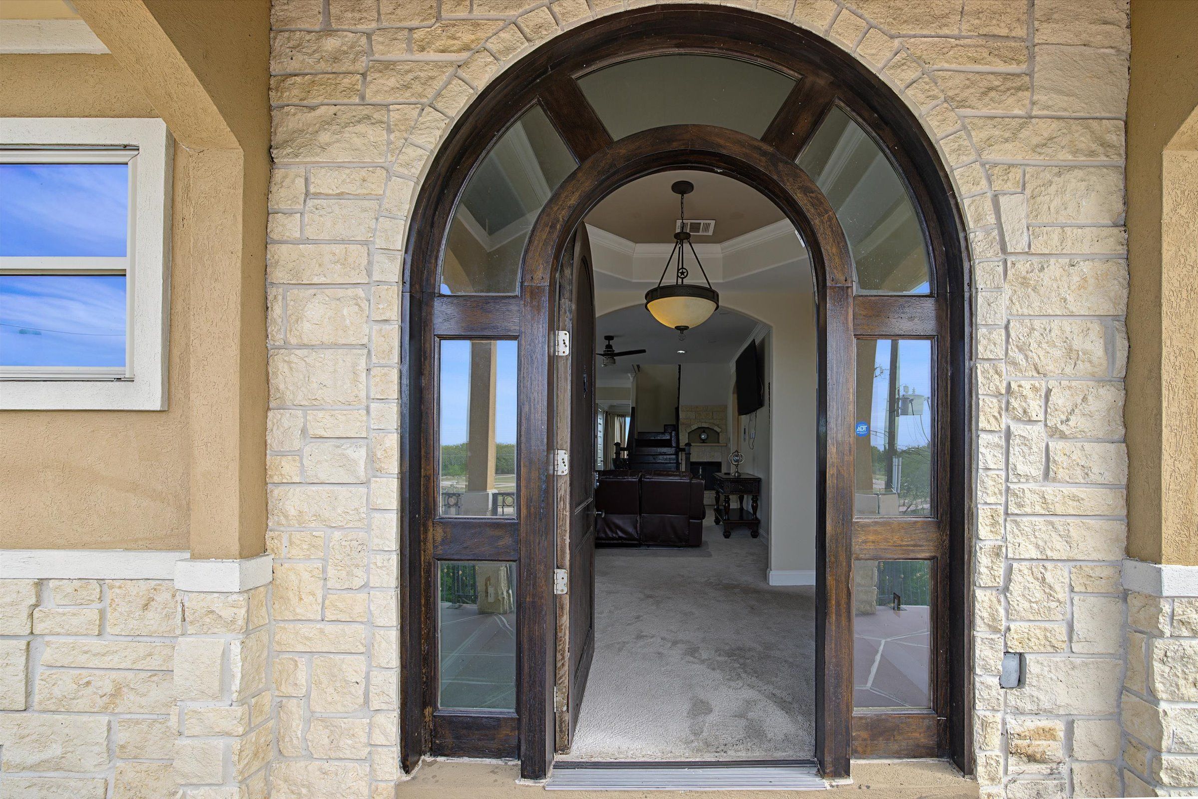 Arched wooden front entrance leading into an open foyer and living space.