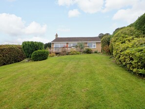 A residential house with a well-maintained lawn and a wooden deck. - Hillset View (Bakewell)