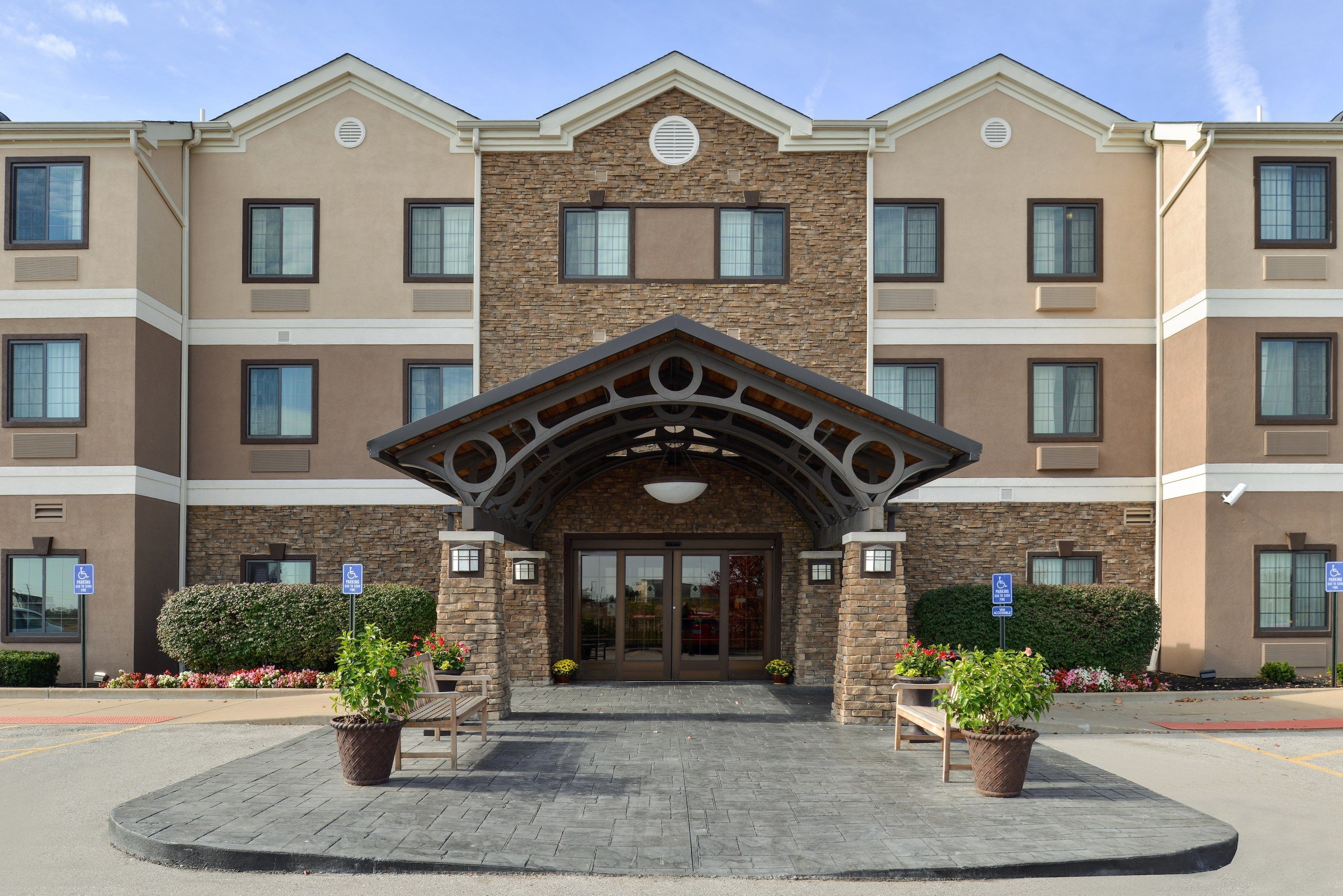 A multi-story hotel with a central entrance, stone facade, and multiple windows.