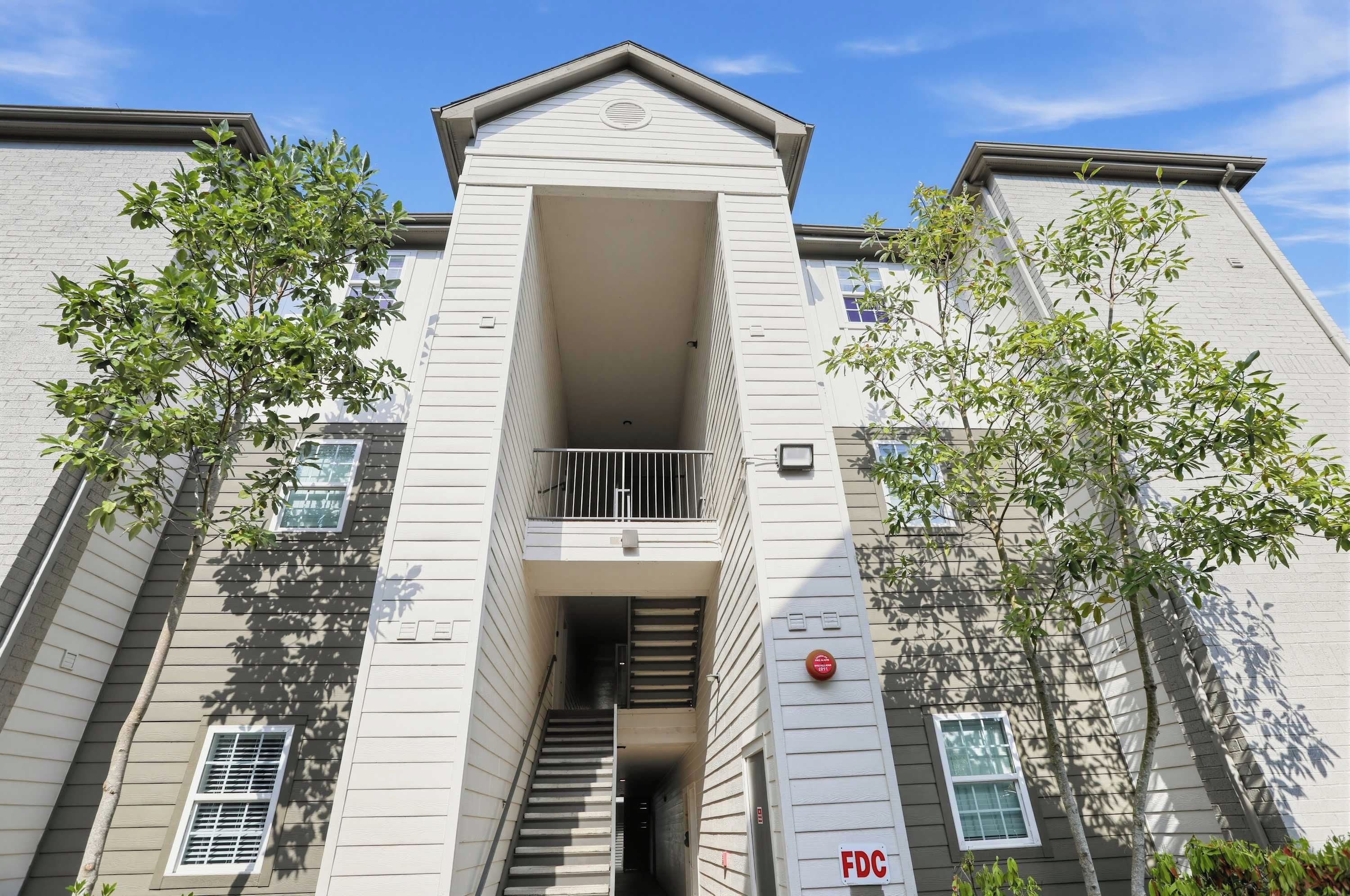 A multi-story building with a central entrance, staircases, and a small balcony.