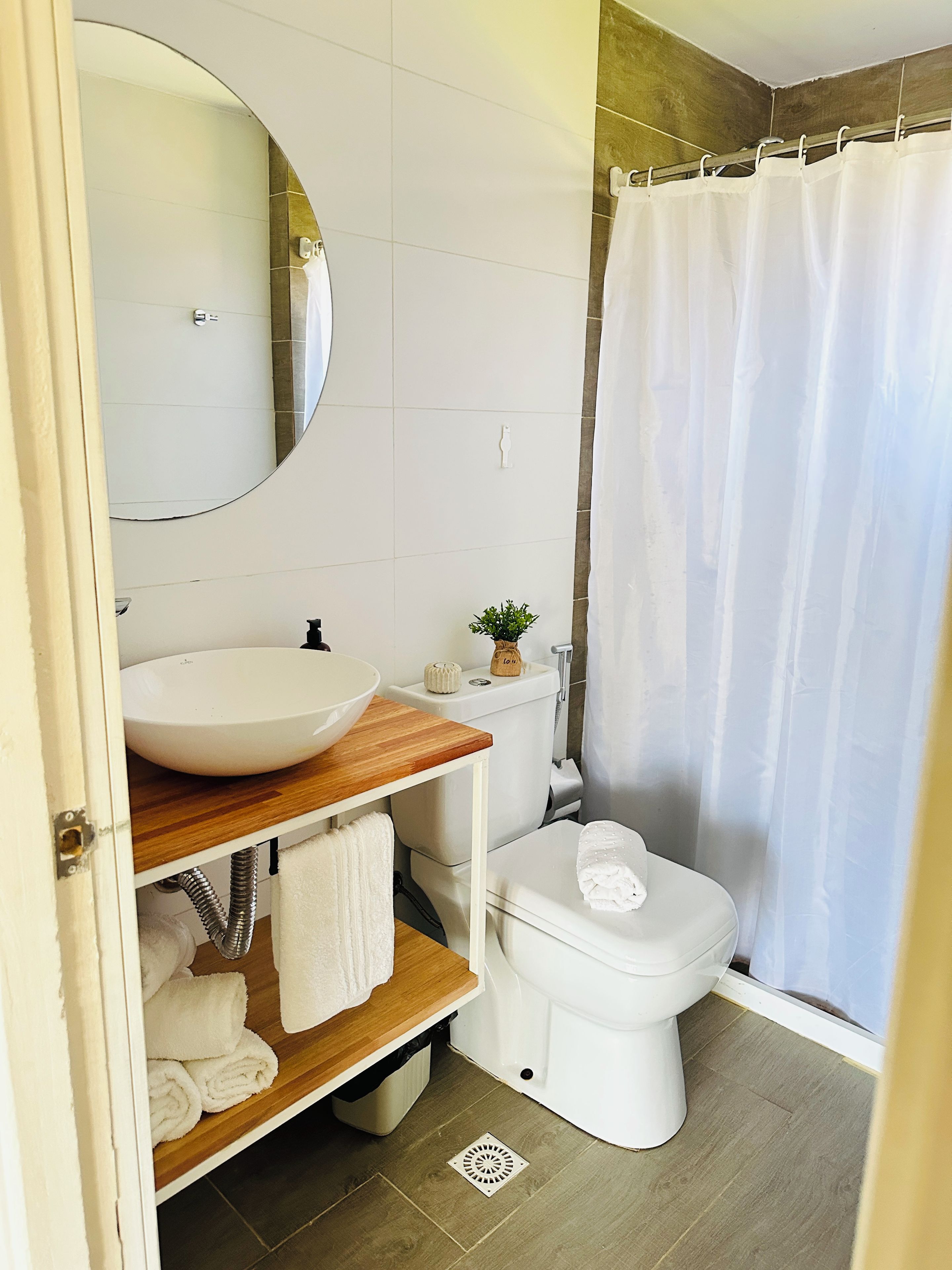 Ein Badezimmer mit weißem Waschbecken, WC und Duschvorhang.