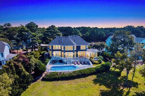 A large, multi-story house with a swimming pool and a covered patio area. - Casa del Sol Soundfront Currituck Club (Corolla)